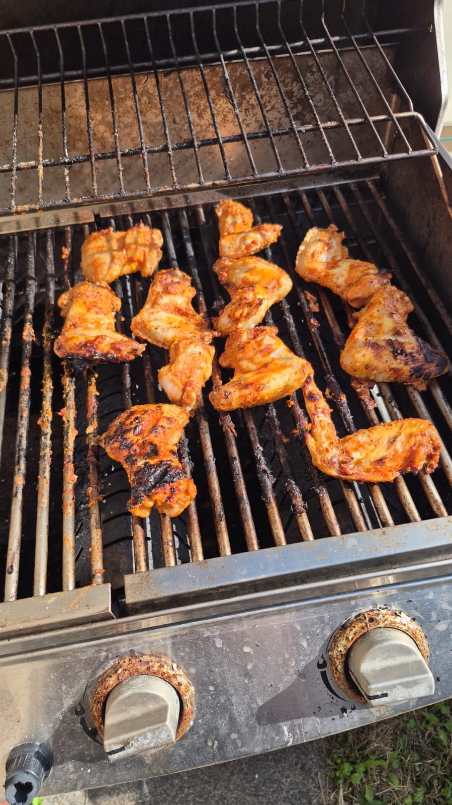 Chicken thighs searing over an open flame